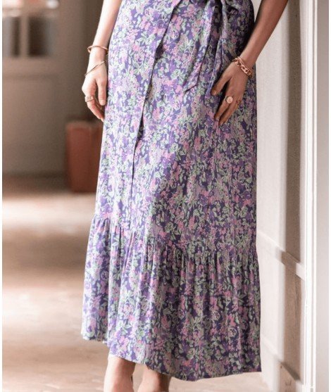 Jupe longue Courtney de la marque La Petite Etoile. Coupe portefeuille fluide, 100% viscose et présentant des fleurs lilas