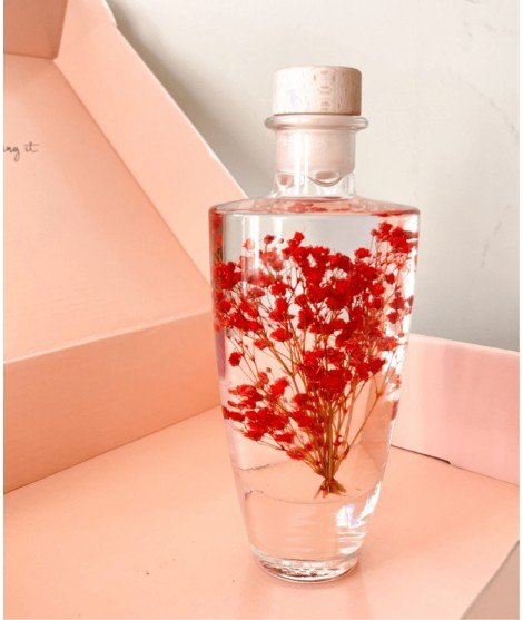 Flacon Floral contenant des fleurs séchées rouges immergées dans une huile végétale non toxique. Contenant de 200 mL